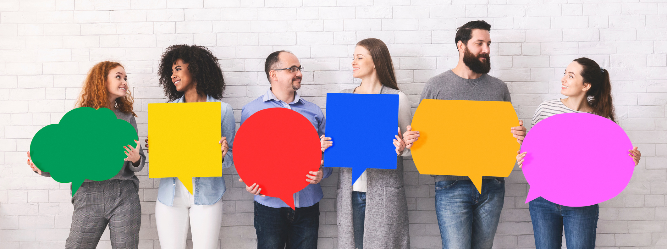 Cheerful diverse people holding empty colorful speech bubbles